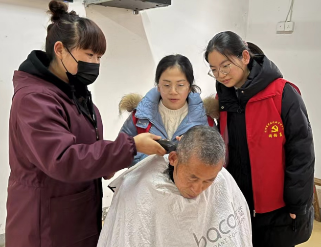 合肥市廬江縣泥河鎮(zhèn)居民劉正芳向青年志愿者傳授理發(fā)技術，弘揚志愿者精神
