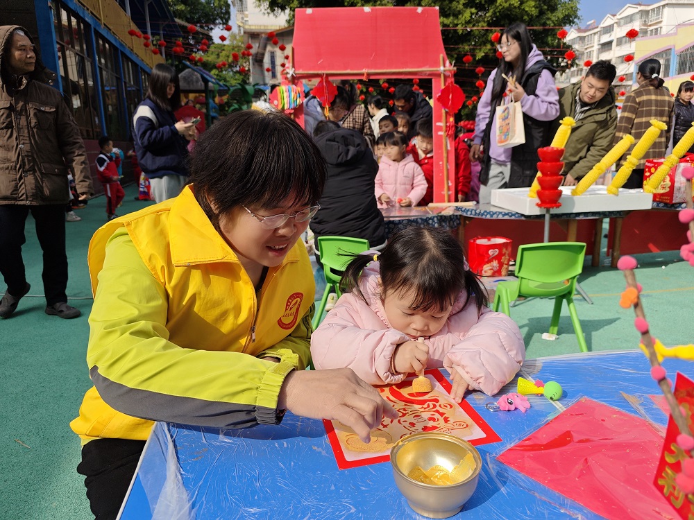 1770108564756701.jpg 【非遺廟會迎新春 傳統(tǒng)文化潤童心】“五老”志愿者協(xié)助小朋友拓印吉祥圖案1.jpg
